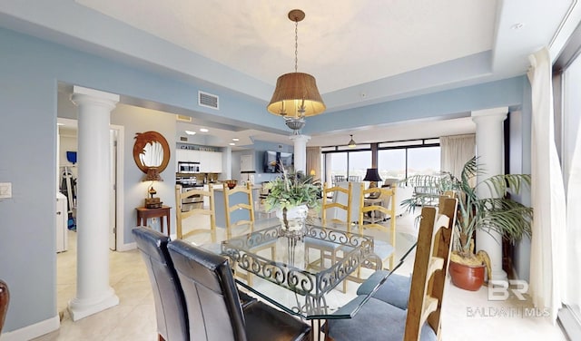 29235 Perdido Beach Blvd Unit 203, Orange Beach, AL 36561 - dining room featuring ornate columns, a tray ceiling, and light tile patterned floors