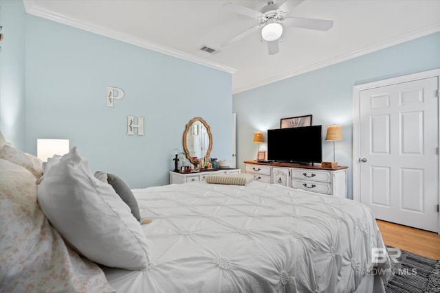 bedroom featuring ceiling fan, crown molding, and light wood-type flooring