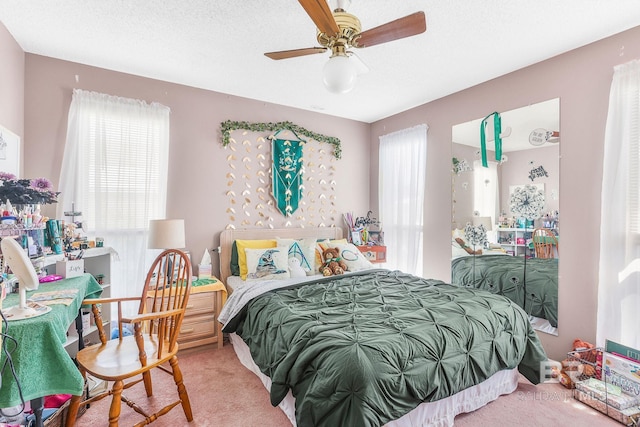 carpeted bedroom featuring ceiling fan and a textured ceiling