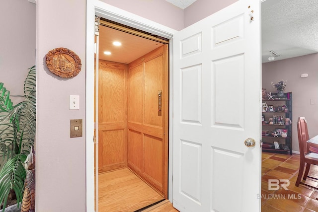 details featuring a textured ceiling and elevator