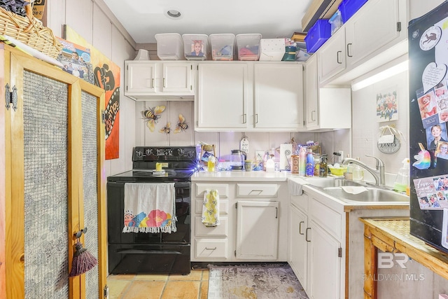 kitchen featuring sink, black electric range, fridge, and white cabinets