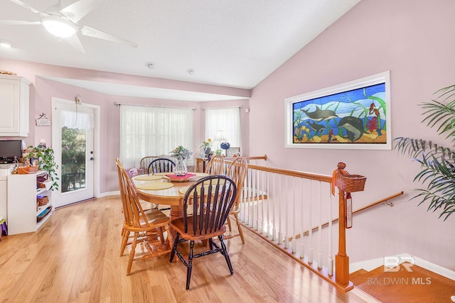 dining space with vaulted ceiling, ceiling fan, and light hardwood / wood-style floors