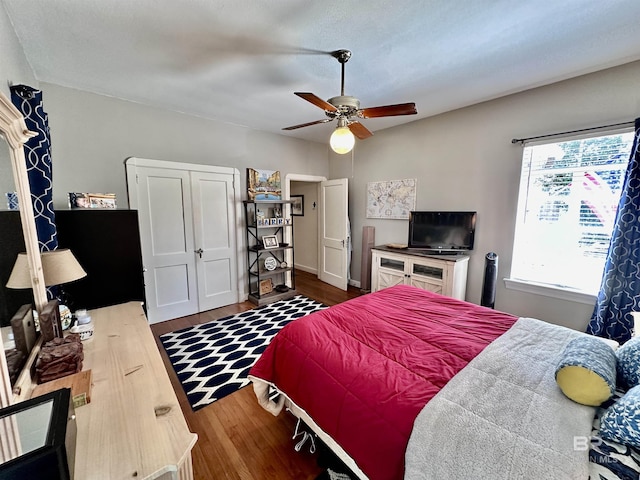 bedroom featuring ceiling fan, wood-type flooring, and multiple windows