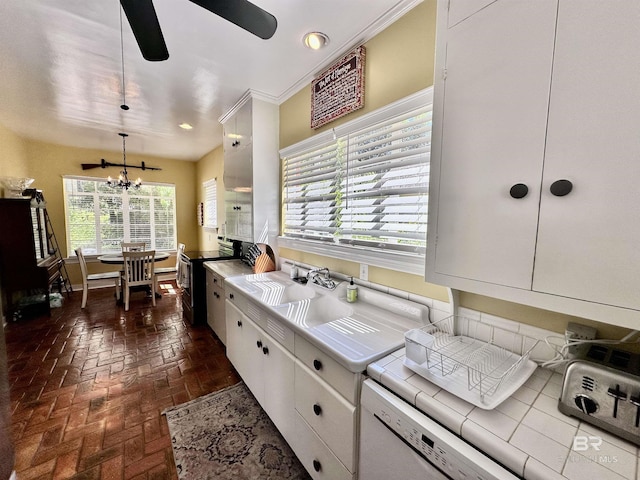 kitchen with pendant lighting, white cabinets, stainless steel electric stove, tile counters, and dishwashing machine