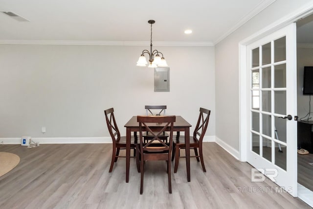 dining room with electric panel, visible vents, baseboards, crown molding, and light wood-style floors