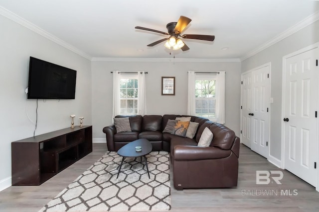 living area with ornamental molding, a wealth of natural light, ceiling fan, and wood finished floors