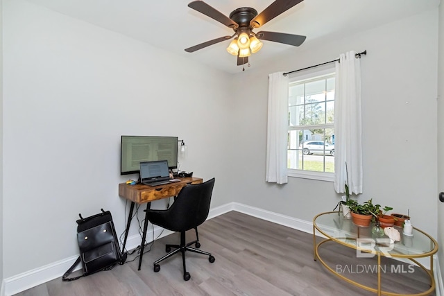 office space featuring light wood-style flooring, baseboards, and a ceiling fan