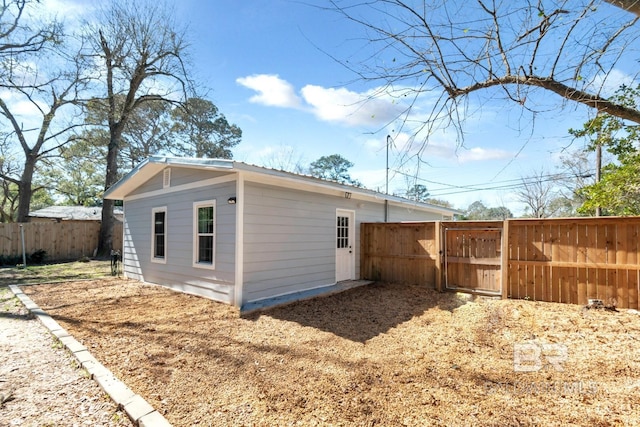 rear view of house featuring fence and a gate