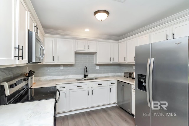 kitchen featuring stainless steel appliances, white cabinets, light countertops, and a sink