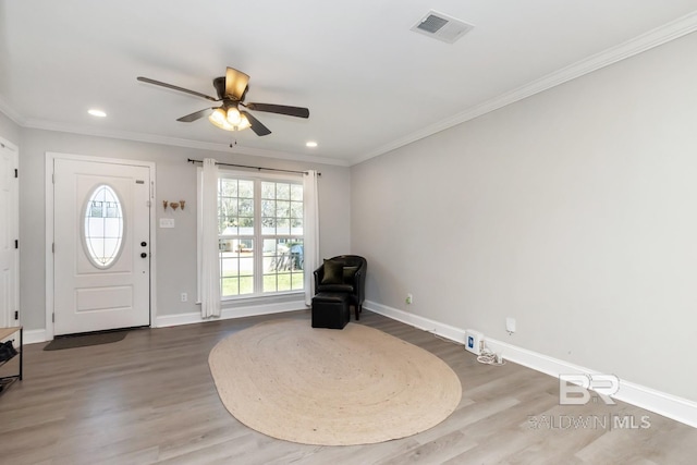 entrance foyer featuring a wealth of natural light, visible vents, crown molding, and baseboards