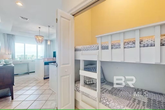 bedroom featuring light tile patterned floors, visible vents, and a notable chandelier