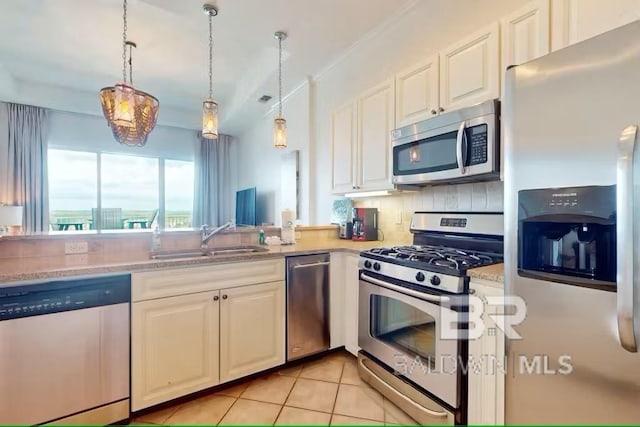 kitchen featuring backsplash, appliances with stainless steel finishes, white cabinets, and a sink