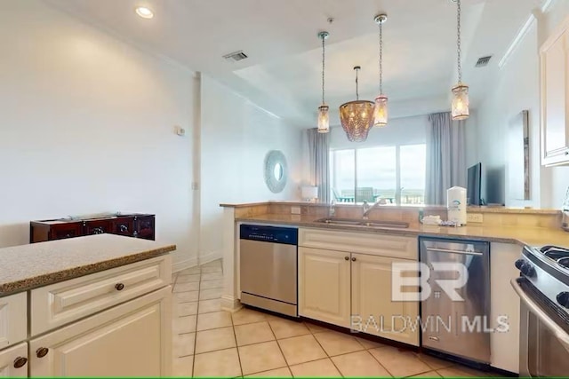 kitchen with stainless steel appliances, a sink, visible vents, white cabinets, and decorative light fixtures