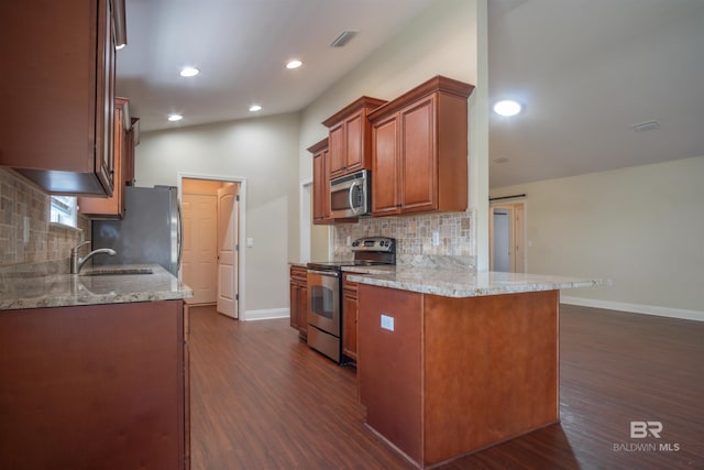 kitchen with light stone counters, backsplash, dark wood-type flooring, and stainless steel appliances