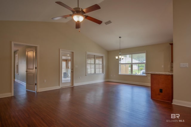 empty room featuring dark hardwood / wood-style floors, high vaulted ceiling, and ceiling fan with notable chandelier