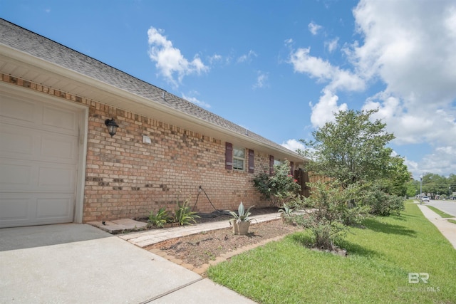 view of side of property featuring a garage and a yard