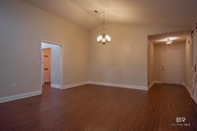 spare room with dark hardwood / wood-style flooring, lofted ceiling, and an inviting chandelier