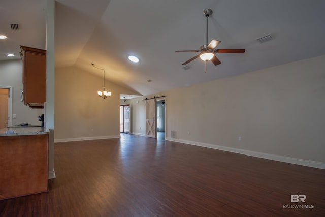 unfurnished living room featuring high vaulted ceiling, dark hardwood / wood-style flooring, a barn door, and ceiling fan with notable chandelier