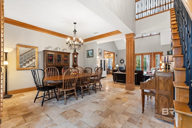 dining space with decorative columns, a high ceiling, ornamental molding, a notable chandelier, and french doors