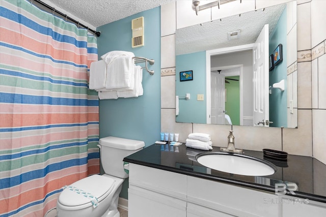 bathroom featuring a textured ceiling, toilet, vanity, and curtained shower