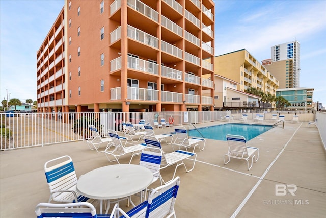 community pool with fence and a patio