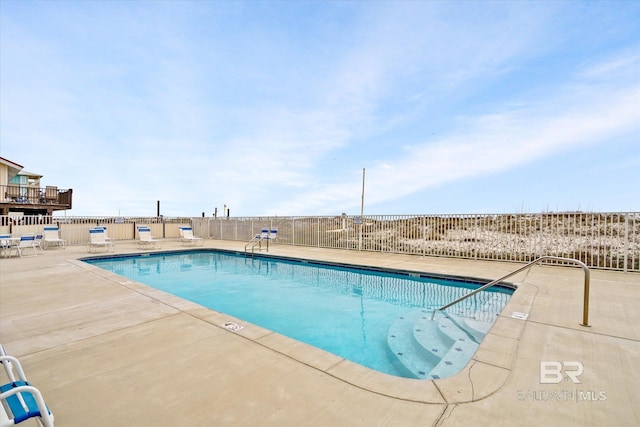 community pool with fence and a patio
