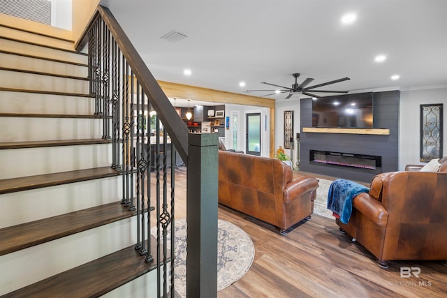 living room with a large fireplace, ceiling fan, and hardwood / wood-style floors