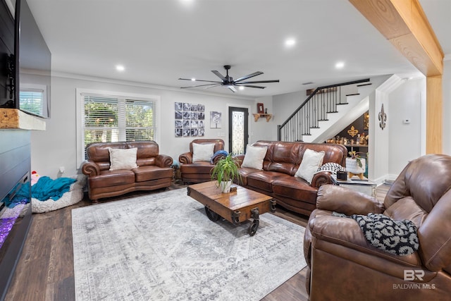 living room featuring dark hardwood / wood-style floors, ceiling fan, and ornamental molding