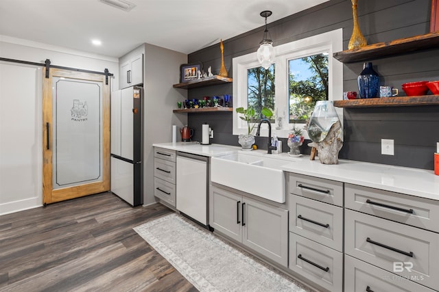 kitchen with dishwasher, dark wood-type flooring, a barn door, white refrigerator, and gray cabinets