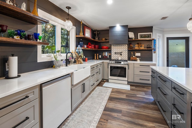 kitchen with appliances with stainless steel finishes, custom range hood, sink, gray cabinets, and hanging light fixtures