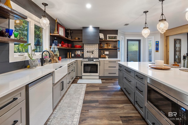 kitchen featuring gray cabinetry, backsplash, decorative light fixtures, appliances with stainless steel finishes, and custom exhaust hood