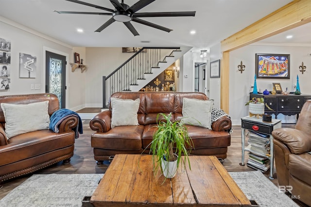 living room featuring beamed ceiling, hardwood / wood-style flooring, ceiling fan, and ornamental molding