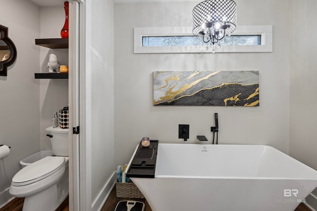 bathroom featuring a chandelier, a bath, toilet, and hardwood / wood-style floors