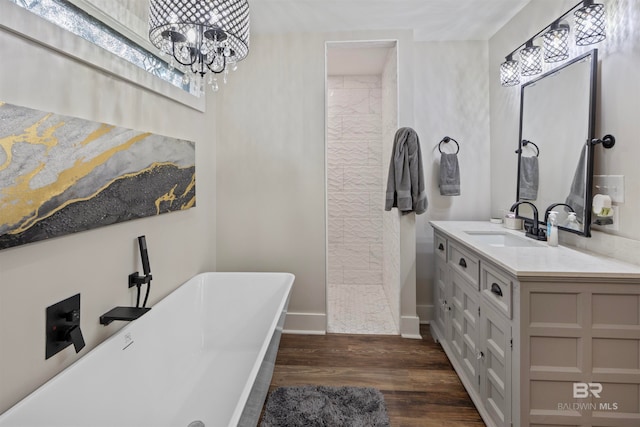 bathroom with a bathtub, vanity, a notable chandelier, and hardwood / wood-style flooring