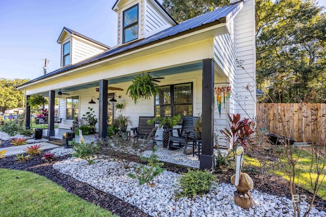 rear view of property with ceiling fan and a porch