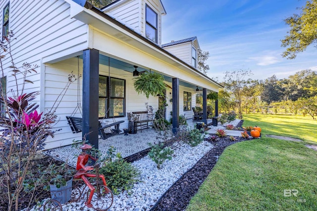 view of side of home featuring a lawn and ceiling fan