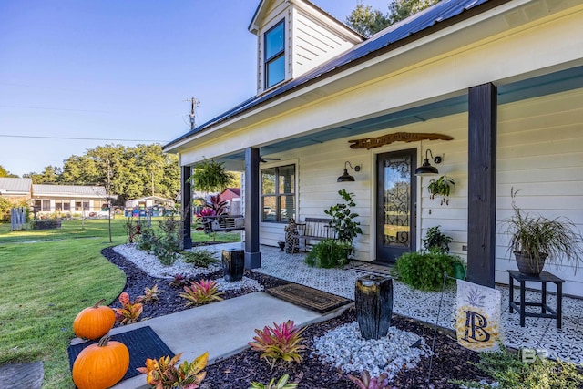 view of exterior entry featuring a porch and a yard