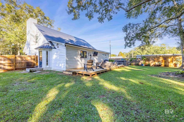 rear view of house with a deck and a lawn