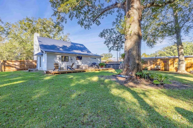 rear view of house with a lawn and a wooden deck