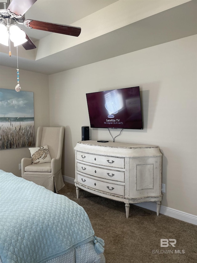 bedroom featuring dark colored carpet, a tray ceiling, ceiling fan, and baseboards