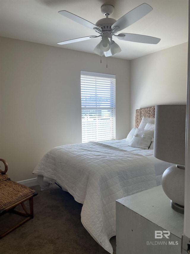 bedroom featuring ceiling fan, dark carpet, and baseboards