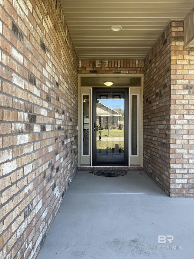 entrance to property featuring brick siding