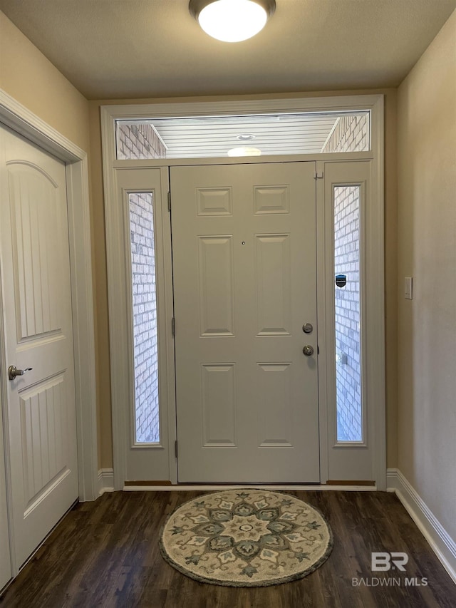 entrance foyer featuring dark wood-type flooring and baseboards