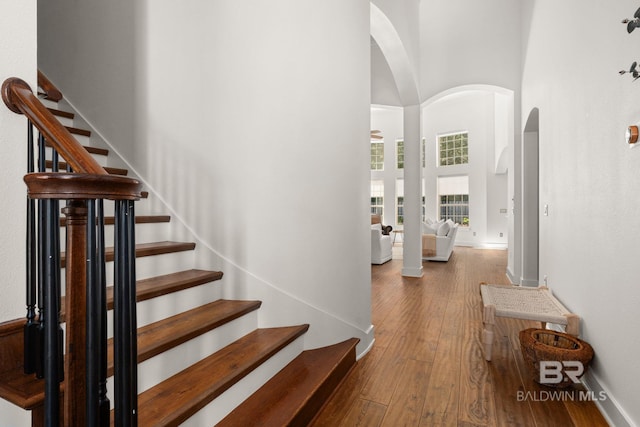 staircase featuring a high ceiling and wood-type flooring