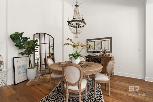 dining space with dark hardwood / wood-style flooring, a chandelier, and a high ceiling