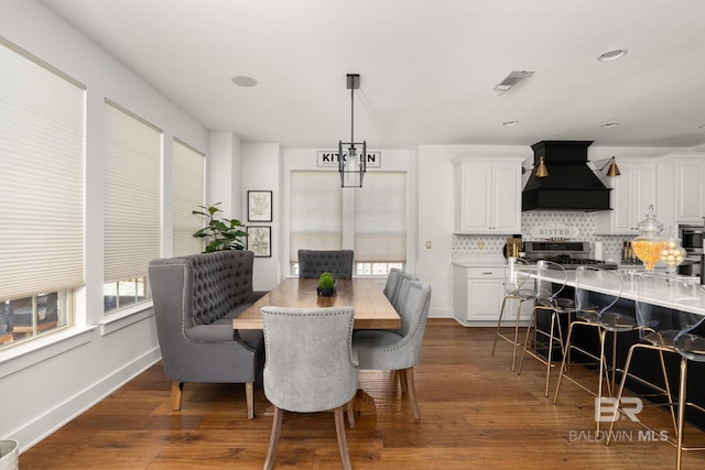 dining space with dark hardwood / wood-style flooring and an inviting chandelier