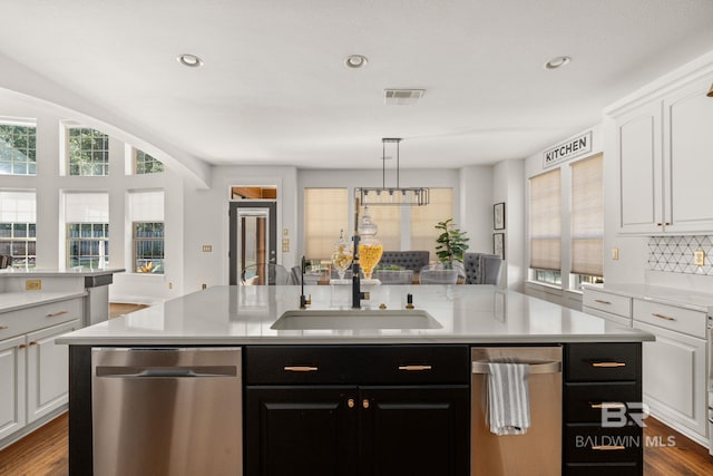 kitchen featuring white cabinets, sink, an island with sink, and dishwasher