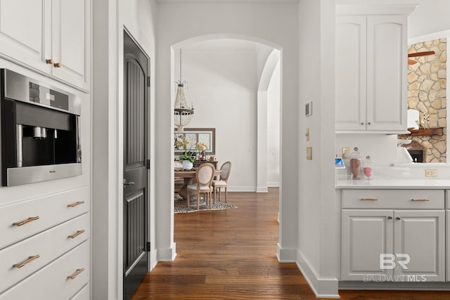 kitchen with white cabinetry, dark wood-type flooring, and oven