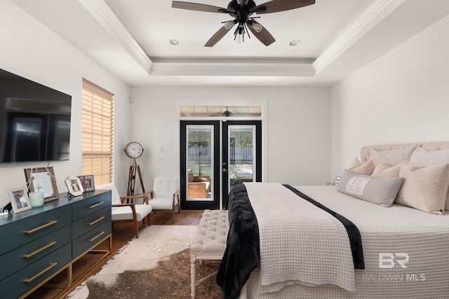 bedroom featuring ornamental molding, dark hardwood / wood-style floors, a tray ceiling, ceiling fan, and access to exterior