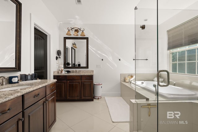 bathroom featuring tile patterned floors, vanity, and tiled tub